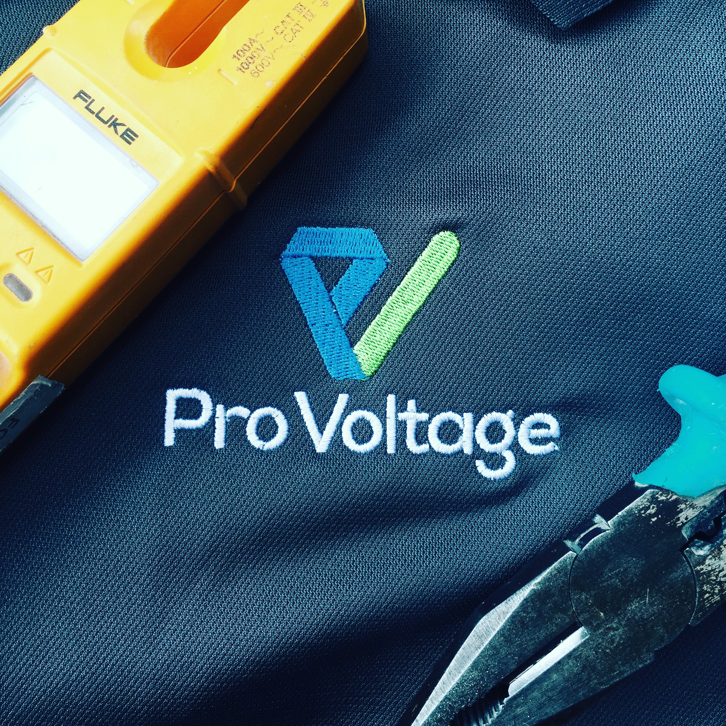ProVoltage branded workwear beside electrical testing equipment